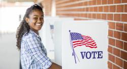 Young smiling voter at voting booth