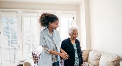 Home care aide helping an elderly black woman