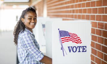 Young smiling voter at voting booth