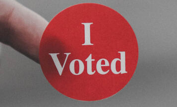 Close up of a red "I Voted" sticker. 