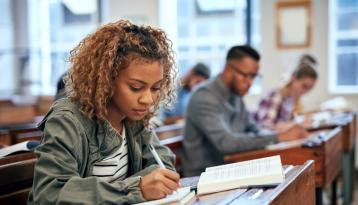 Black student in classroom, writing