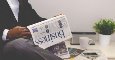 Business man reading the business section of a newspaper