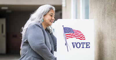 Latina woman voting at a voting booth
