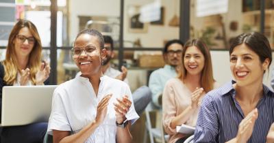 Diverse audience smiling and clapping