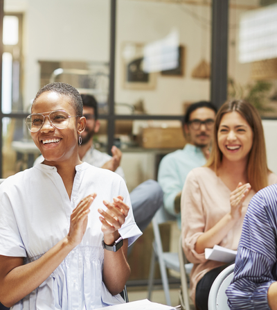 Diverse audience smiling and clapping